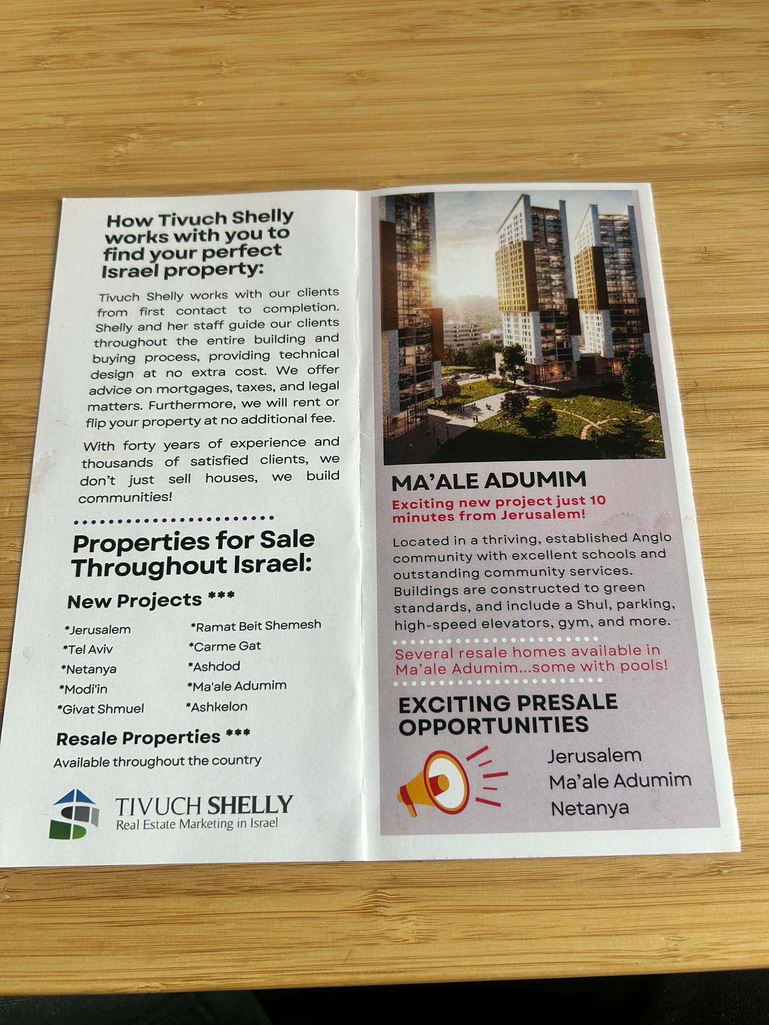 صورة لكتيّب شركة تيفوخ شيلي مفتوحاً، تظهر فيه صفحة بعنوان «Properties for Sale Throughout Israel» تُدرِج مستوطنة معاليه أدوميم، وصفحة أخرى تروّج لمشروع سكني في معاليه أدوميم.